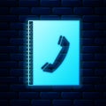Glowing neon Phone book icon isolated on brick wall background. Address book. Telephone directory. Vector