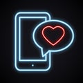 Glowing neon phone with red heart emoji message on screen. Bright light love sign.