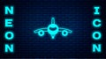 Glowing neon Plane icon isolated on brick wall background. Flying airplane icon. Airliner sign. Vector Royalty Free Stock Photo