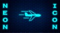 Glowing neon Plane icon isolated on brick wall background. Flying airplane icon. Airliner sign. Vector Royalty Free Stock Photo