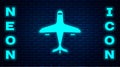 Glowing neon Plane icon isolated on brick wall background. Flying airplane icon. Airliner sign. Vector Royalty Free Stock Photo