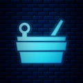 Glowing neon Sauna bucket and ladle icon isolated on brick wall background. Vector