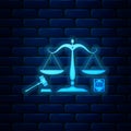 Glowing neon Scales of justice, gavel and book icon isolated on brick wall background. Symbol of law and justice Royalty Free Stock Photo