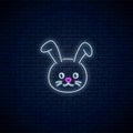 Glowing neon sign of cute rabbit in kawaii style on dark brick wall background. Cartoo happy smiling bunny in neon style