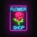Glowing neon sign of flower shop in rectangle frame on dark brick wall background. Design of floral store signboard.