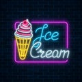 Glowing neon sign of ice cream with cherry on dark brick wall background. Fruit ice-cream in waffle cone. Royalty Free Stock Photo