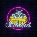 Glowing neon sign of octoberfest festival with two beer mugs on dark brick wall background.