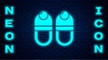 Glowing neon Slippers icon isolated on brick wall background. Flip flops sign. Vector Royalty Free Stock Photo