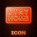 Glowing neon Stay home icon isolated on brick wall background. Corona virus 2019-nCoV. Vector.