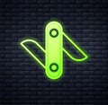 Glowing neon Swiss army knife icon isolated on brick wall background. Multi-tool, multipurpose penknife. Multifunctional