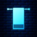 Glowing neon Towel on a hanger icon isolated on brick wall background. Bathroom towel icon. Vector