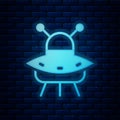 Glowing neon UFO flying spaceship icon isolated on brick wall background. Flying saucer. Alien space ship. Futuristic Royalty Free Stock Photo