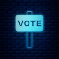 Glowing neon Vote icon isolated on brick wall background. Vector