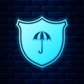 Glowing neon Waterproof icon isolated on brick wall background. Shield and umbrella. Water protection sign. Water