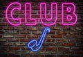Glowing Nightclub neon sign on brick wall.