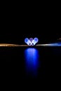 Glowing Olympic rings reflected in the harbor