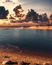 Glowing orange cloudy sunset seabeach with pebbles