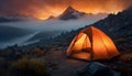 glowing orange tourist tent on a background of mountains, fog and forest, tourism, travel Royalty Free Stock Photo