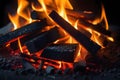 Glowing orange and yellow hot burning charcoal briquettes in a fireplace with embers and ash