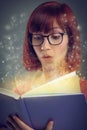 Glowing pages, book and woman with a story, magic and education on grey studio background. Person, reader and girl with Royalty Free Stock Photo