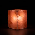 Glowing pink Himalayan salt lamp, cube-shaped with a rough surface. Emits a warm, Royalty Free Stock Photo