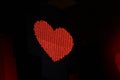 Glowing pixel red heart of LED lamps on black background