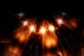 Glowing radiant stars on bright orange beams. Kaleidoscopic pattern. Blurred image