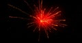 Glowing red firework exploding on black background with defocussed blue spots Royalty Free Stock Photo