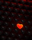 Glowing red-glass heart surrounded by dark hearts Royalty Free Stock Photo