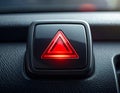 Glowing red hazard warning light button on a car dashboard image photo Royalty Free Stock Photo