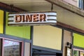 A glowing red neon sign advertises the entrance to a city diner. Royalty Free Stock Photo