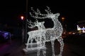 Glowing reindeer made of wire and light bulbs. Christmas decorations. Christmas Lights on reindeer shape wire frame mesh. Deer