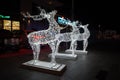 Glowing reindeer made of wire and light bulbs. Christmas decorations. Christmas Lights on reindeer shape wire frame mesh. Deer