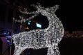 Glowing reindeer made of wire and light bulbs. Christmas decorations. Christmas Lights on reindeer shape wire frame mesh. Deer