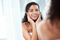 Glowing skin is every womans dream. a beautiful young woman looking pleased while looking in the bathroom mirror. Royalty Free Stock Photo