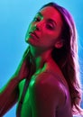 Glowing skincare, portrait or neon lighting on isolated blue background and hands on neck, body or skin. Beauty model