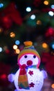 Glowing snowman on Christmas tree background with garlands Royalty Free Stock Photo