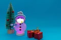 Glowing snowman, wears face mask,presents and Christmas tree with copy space.new year celebration Royalty Free Stock Photo