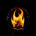 A glowing sphere with a clear glass surface envelops a vibrant orange flame. The Royalty Free Stock Photo
