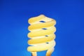 Glowing spiral light bulb on color background Royalty Free Stock Photo