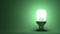Glowing spiral light bulb on green Royalty Free Stock Photo