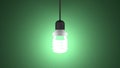 Glowing spiral light bulb hanging on green Royalty Free Stock Photo