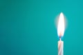 Glowing thin white candle on blue background