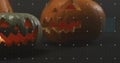 Glowing two carved jack-o\'-lanterns casting orange reflections on studio tabletop, calibration grid Royalty Free Stock Photo