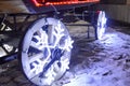 Glowing wheels, Christmas garland in the form of snowflakes on wooden cart wheels
