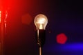 glowing light bulb against blue and red wall background Royalty Free Stock Photo