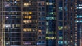 Glowing windows in multistory modern glass residential building light up at night timelapse. Royalty Free Stock Photo