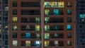 Glowing windows in multistory modern glass residential building light up at night timelapse. Royalty Free Stock Photo