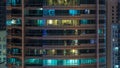 Glowing windows in multistory modern glass residential building light up at night timelapse. Royalty Free Stock Photo