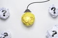 Glowing Yellow scrap paper ball with drawing wire harness among white scrap paper with question mark for creative thinking idea